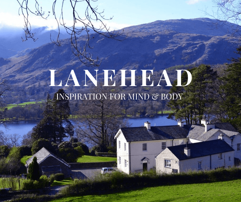 A collection of white houses and buildings in front of a lake with hills around it. The words 'Lanehead' and 'Inspiration for your mind & body' are in front of this image.