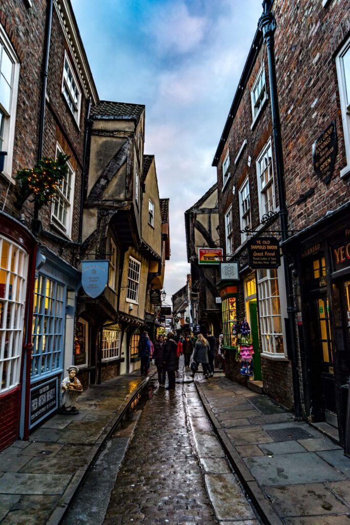 People walk down The Shambles, a famous historic street in York, UK.